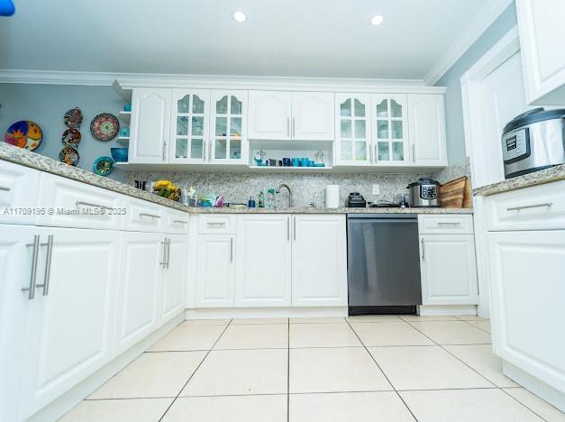 kitchen with ornamental molding, dishwashing machine, light stone countertops, and white cabinets