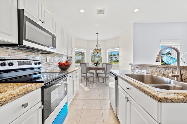 kitchen featuring stainless steel appliances, light tile patterned floors, white cabinets, and sink