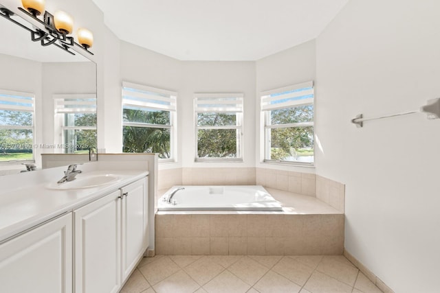 bathroom featuring tile patterned flooring, tiled tub, and vanity