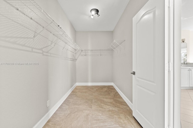 spacious closet with light tile patterned floors and sink