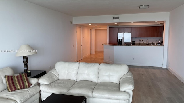 living room with sink and light wood-type flooring