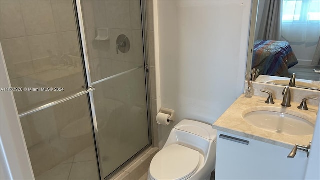 bathroom featuring vanity, a shower with shower door, and toilet