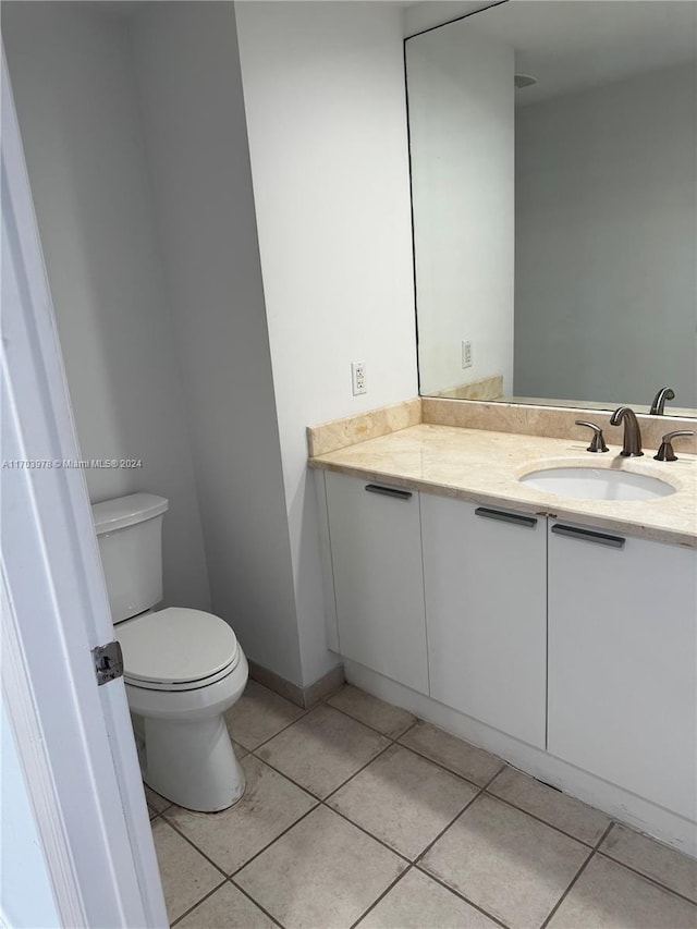 bathroom with tile patterned flooring, vanity, and toilet