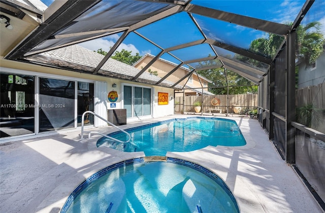 view of pool featuring a lanai, an in ground hot tub, and a patio