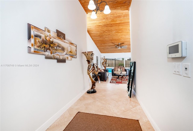 hallway featuring tile patterned floors, a chandelier, high vaulted ceiling, and wooden ceiling