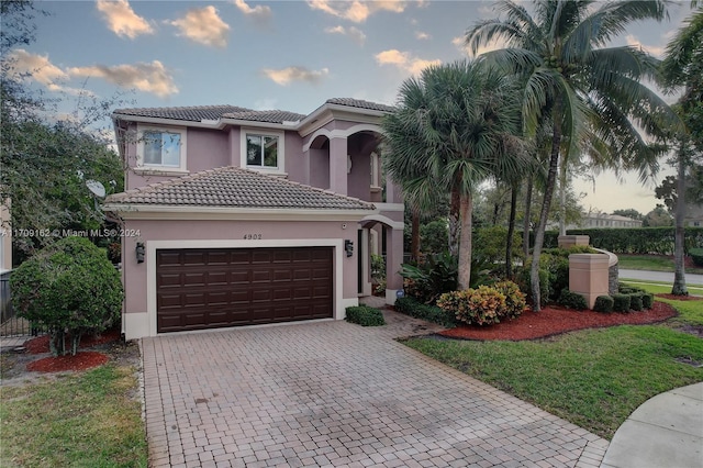 mediterranean / spanish-style house featuring a yard and a garage