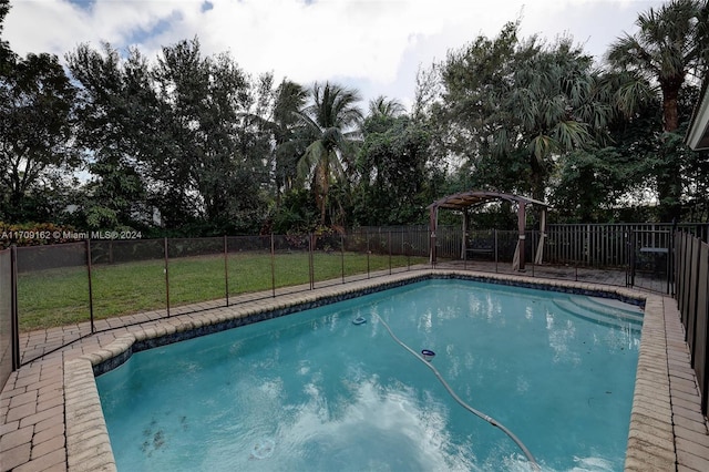 view of pool with a lawn and a pergola