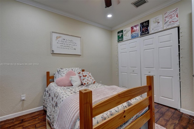 bedroom with dark hardwood / wood-style floors, ceiling fan, crown molding, and a closet