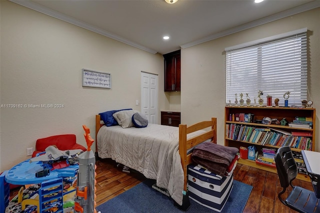 bedroom with ornamental molding, dark wood-type flooring, and a closet