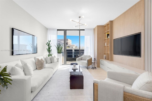 living room featuring light hardwood / wood-style flooring, an inviting chandelier, and a wall of windows