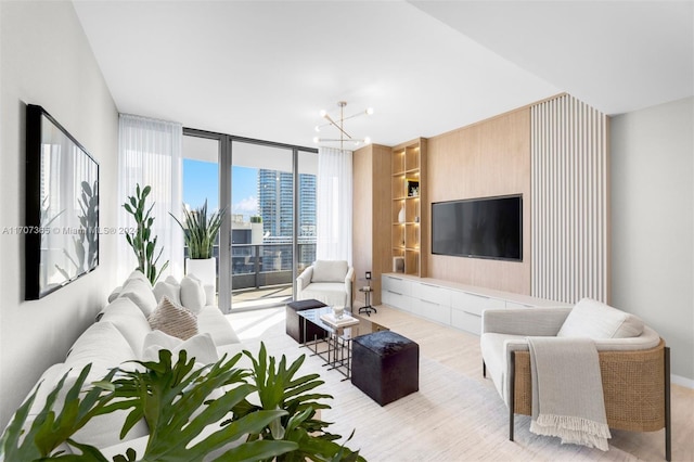 living room featuring expansive windows, light hardwood / wood-style floors, and a chandelier