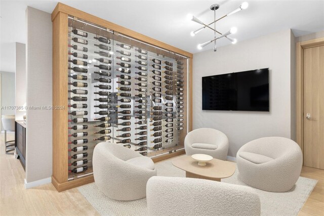 wine room featuring light wood-type flooring and a notable chandelier