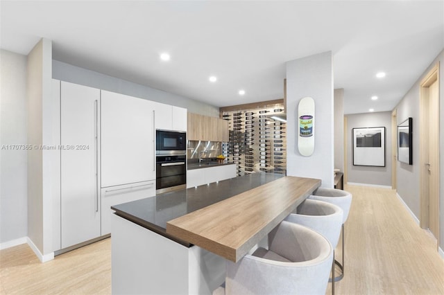 kitchen featuring white cabinets, light hardwood / wood-style floors, and stainless steel appliances