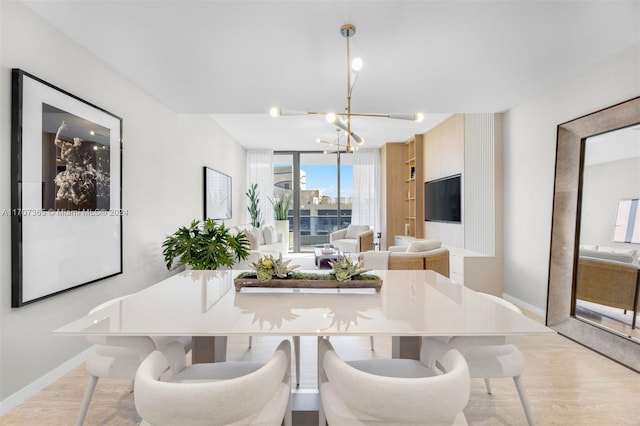 dining room with light hardwood / wood-style flooring and a notable chandelier