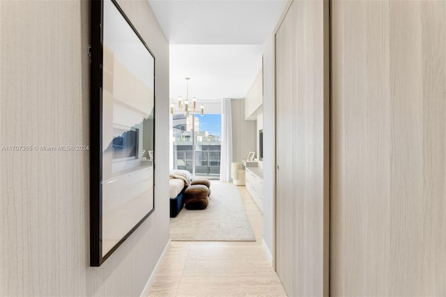 corridor with expansive windows and a chandelier