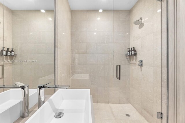 bathroom featuring sink, shower with separate bathtub, and tile walls