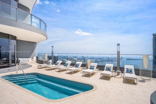 view of swimming pool featuring a patio area, a water view, and an in ground hot tub