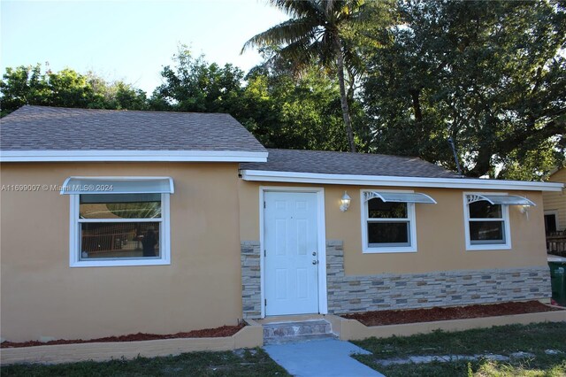 1918 NW 82nd St, Miami, FL 33147 - bungalow-style home with stone siding, stucco siding, and roof with shingles
