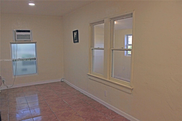 unfurnished room with a wall unit AC