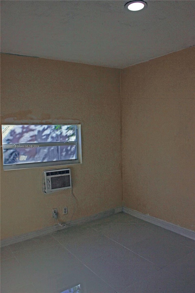 tiled spare room with a wall mounted AC