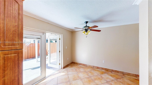 tiled empty room featuring ceiling fan, a textured ceiling, and ornamental molding