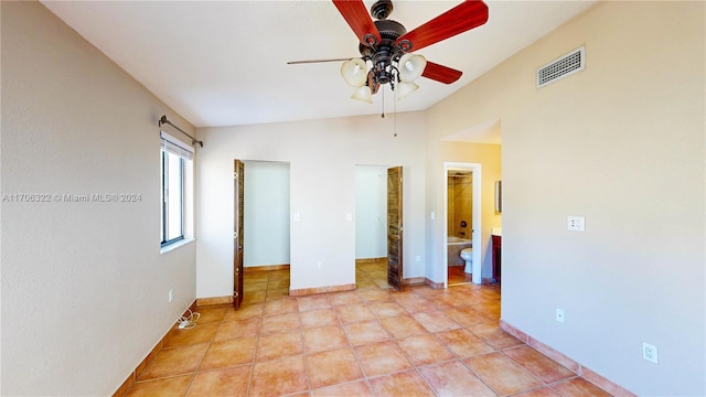 tiled spare room featuring ceiling fan and vaulted ceiling