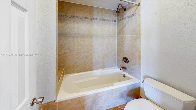 bathroom with tiled shower / bath and toilet