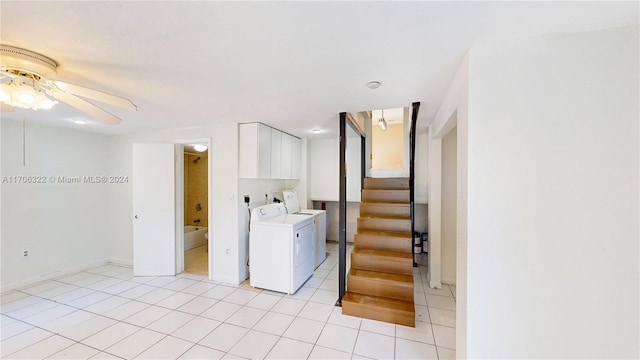 laundry room featuring washing machine and clothes dryer, ceiling fan, light tile patterned floors, and cabinets