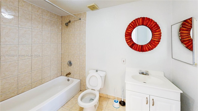 full bathroom with tile patterned flooring, vanity, tiled shower / bath combo, and toilet