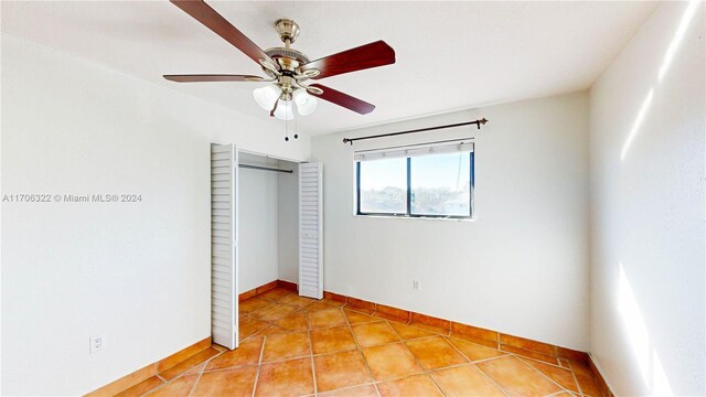 unfurnished bedroom with light tile patterned flooring, a closet, and ceiling fan