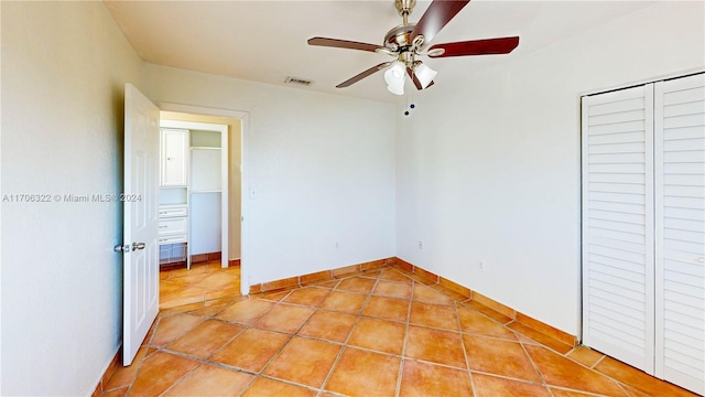 unfurnished bedroom featuring ceiling fan, a closet, and light tile patterned floors