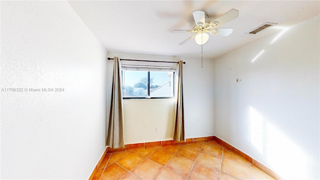 tiled empty room featuring ceiling fan