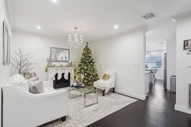 living room featuring a notable chandelier, ornamental molding, and dark wood-type flooring