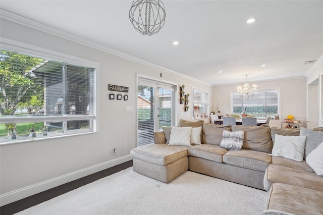 living room with hardwood / wood-style flooring, a notable chandelier, and ornamental molding