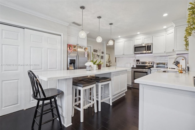 kitchen featuring stainless steel appliances, sink, decorative light fixtures, dark hardwood / wood-style floors, and white cabinetry