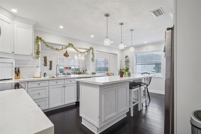 kitchen with white cabinets, decorative backsplash, sink, and decorative light fixtures