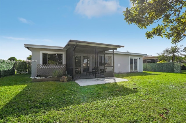 back of property featuring a yard and a sunroom