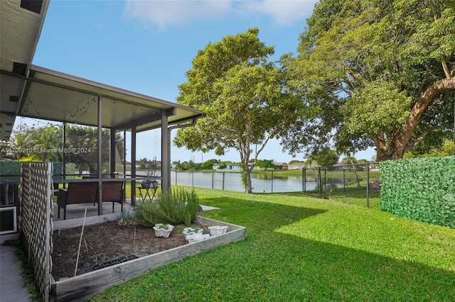 view of yard featuring a water view and a sunroom