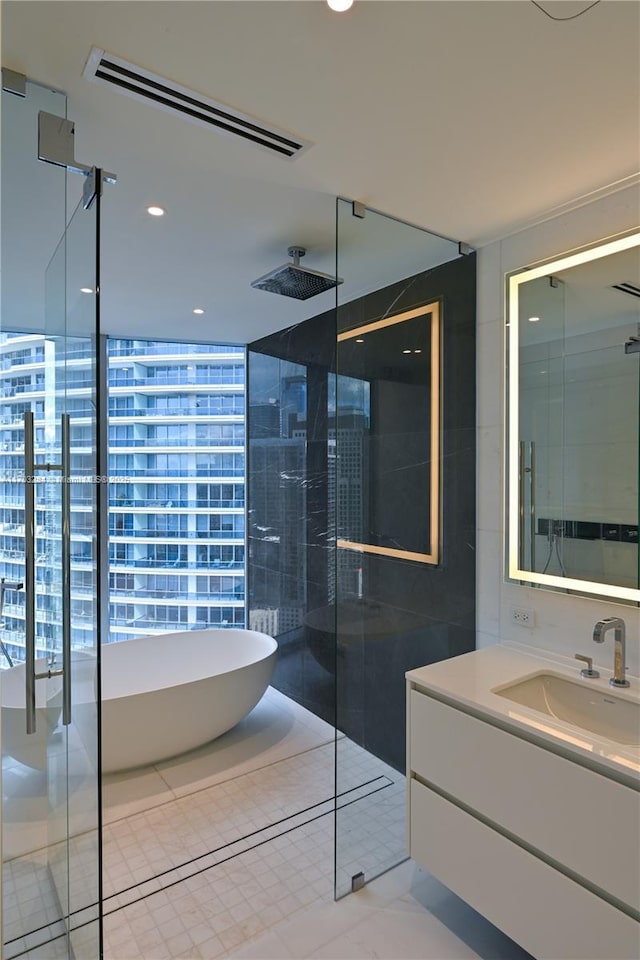 bathroom featuring independent shower and bath, expansive windows, tile patterned floors, and vanity