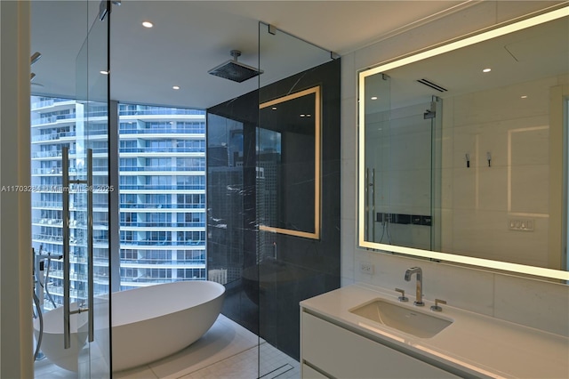 bathroom with independent shower and bath, tile patterned flooring, a wall of windows, and vanity