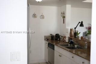 kitchen featuring dishwasher, white cabinetry, and sink