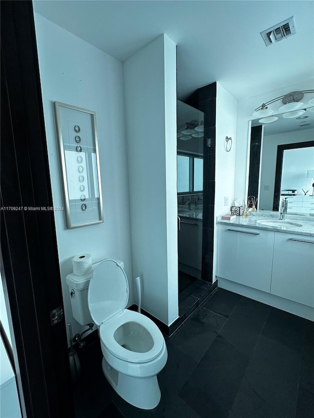 bathroom featuring toilet, vanity, and tile patterned floors