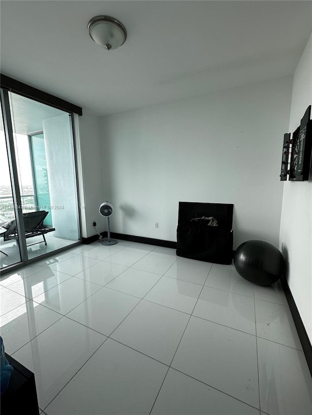 spare room featuring a wall of windows and light tile patterned flooring