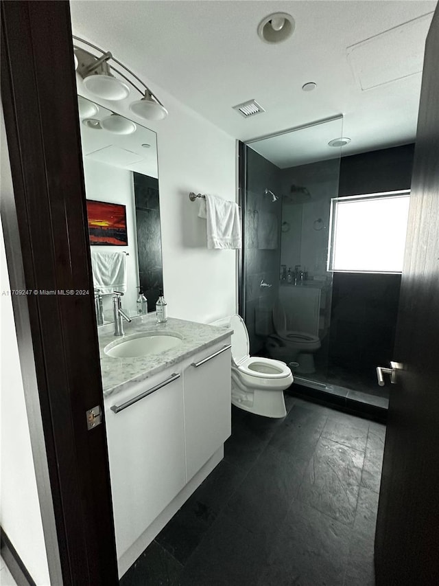 bathroom with vanity, toilet, and a tile shower