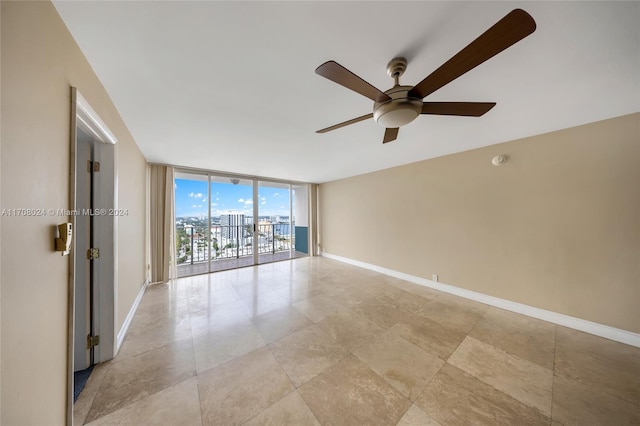 unfurnished room featuring expansive windows and ceiling fan