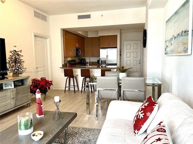 living room featuring light wood-style floors and visible vents