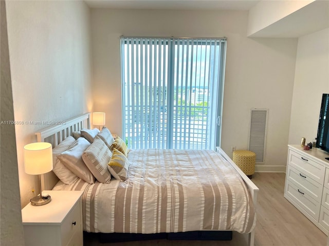 bedroom featuring light wood-style flooring, visible vents, and baseboards