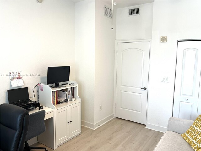 home office featuring baseboards, visible vents, and light wood-style floors
