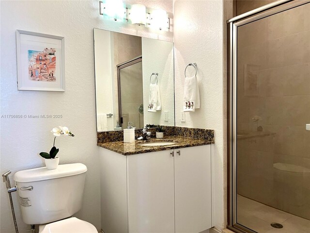 bathroom featuring vanity, toilet, and a stall shower