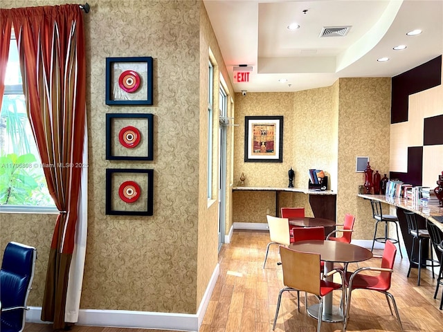 dining room with baseboards, visible vents, recessed lighting, wood finished floors, and a raised ceiling